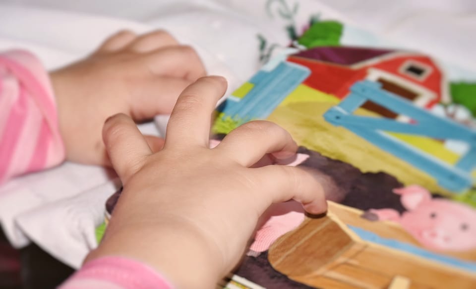 A toddler's hands on a watercolor painting.