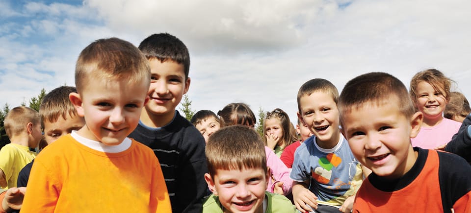 A small crowd of kids looking at the camera.